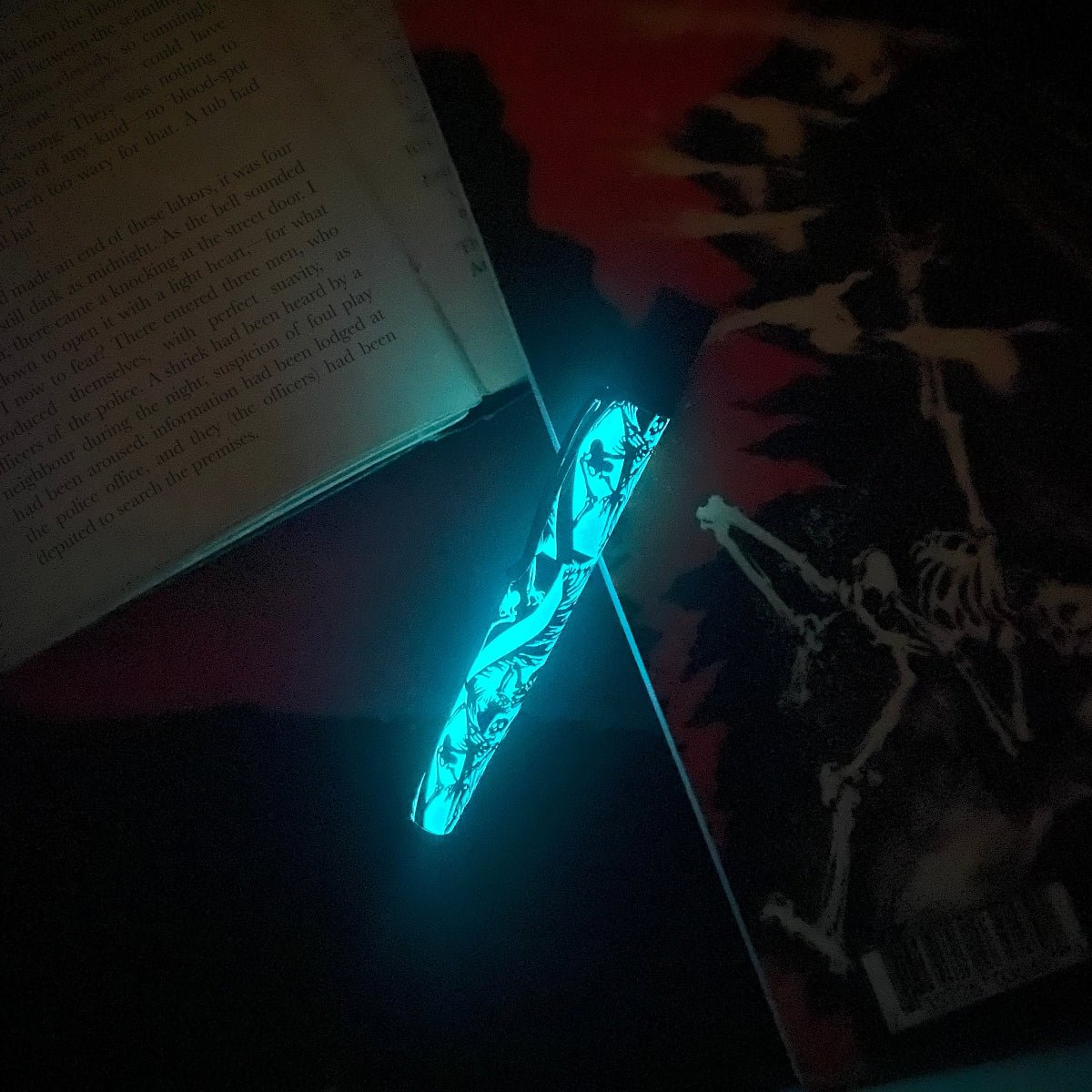 Raven 6 glow-in-the-dark pen beside an open book